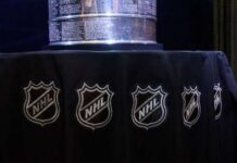Close-up of the Stanley Cup displayed on a black tablecloth with NHL logos
