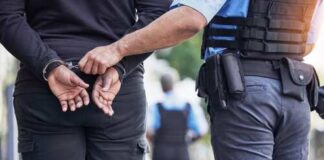 Police officer handcuffing a suspect in an outdoor setting