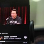 Elon Musk being interviewed on a podcast displayed on a smartphone