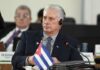 Cuban delegate at a conference wearing headphones and seated at a table