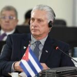 Cuban delegate at a conference wearing headphones and seated at a table