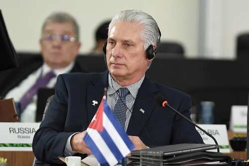 Cuban delegate at a conference wearing headphones and seated at a table