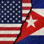 A cracked surface displaying the flags of the United States and Cuba