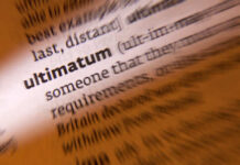 Close-up of a dictionary page highlighting the word 'ultimatum'