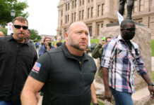 A group of men walking through a crowd at a protest
