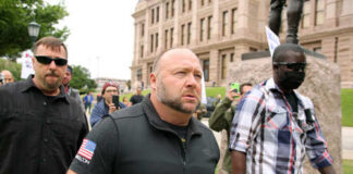 A group of men walking through a crowd at a protest