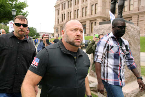 A group of men walking through a crowd at a protest