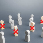 Wooden figures representing people with some marked for exclusion