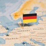 A small German flag placed on a map of Europe highlighting Germany