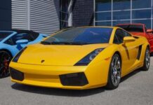 A bright yellow Lamborghini sports car parked in front of a modern building