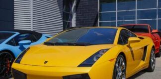 A bright yellow Lamborghini sports car parked in front of a modern building