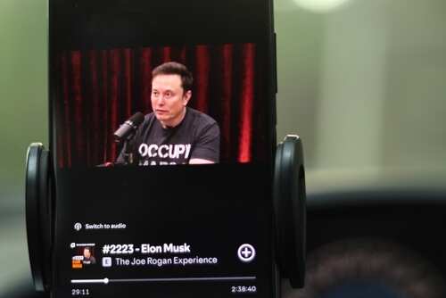 Elon Musk being interviewed on a podcast displayed on a smartphone