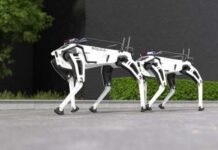 Two robotic police dogs standing on a pavement