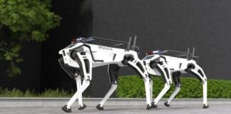 Two robotic police dogs standing on a pavement