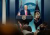 A speaker at a podium during a press conference at the White House