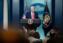 A speaker at a podium during a press conference at the White House