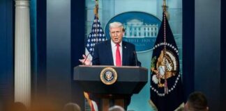 A speaker at a podium during a press conference at the White House