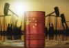 An oil barrel featuring the Chinese flag against a sunset backdrop with oil rigs