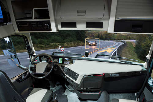 shutterstock_727086667.jpg Interior view of a truck with a focus on the dashboard and road ahead
