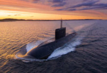 A submarine navigating through the ocean during sunset