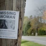 Missing person poster on a telephone pole with a woman's photo