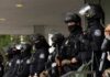 Group of law enforcement officers in riot gear standing in formation