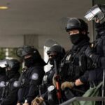 Armed Veteran on the Loose—Escapes Massive Manhunt Group of law enforcement officers in riot gear standing in formation
