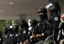 Group of law enforcement officers in riot gear standing in formation