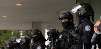 Group of law enforcement officers in riot gear standing in formation