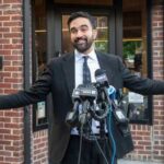 Governor’s SHOCKING Cartel Ties Exposed! Man in a suit speaking at a press conference with microphones in front of him