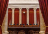 Surveillance Catches SHOCKING Attack – Brutal Stabbing! Interior view of a courtroom with red curtains and marble columns