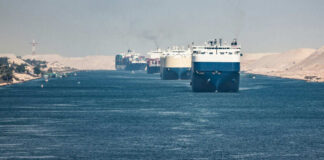 Multiple cargo ships in a narrow canal passage