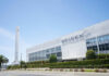 SpaceX building with rocket and palm tree outside