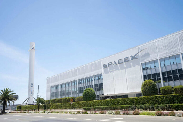 2409679507 SpaceX building with rocket and palm tree outside