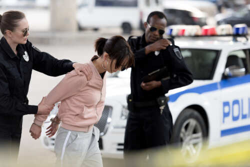 Police officers arresting a suspect in an urban environment