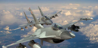 Two military fighter jets flying in formation above the clouds