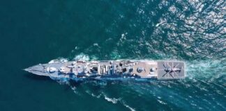 Aerial view of a naval ship navigating through the ocean