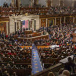 Vance Warns: Elections Rigged For Decades? People in a large government assembly hall meeting