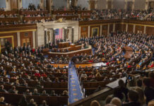 Vance Warns: Elections Rigged For Decades? People in a large government assembly hall meeting